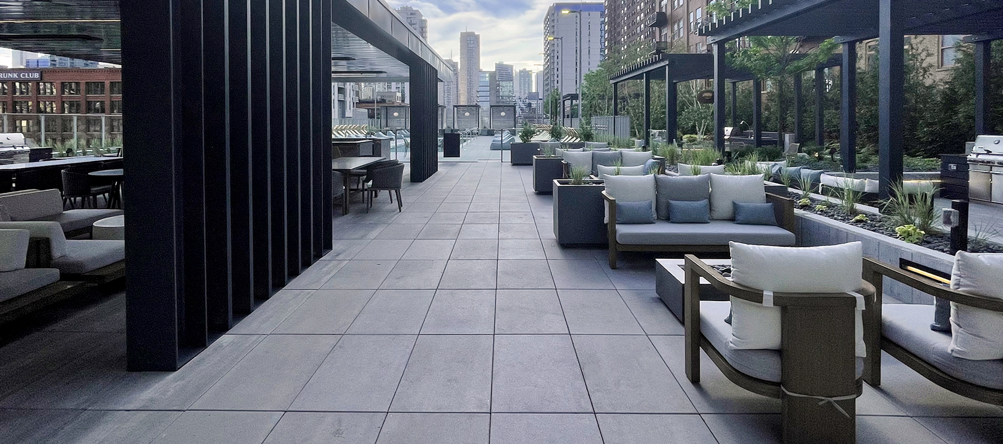 A view of the 369 W Grand roof deck outdoor kitchens and seating areas overlooking the Chicago skyline.