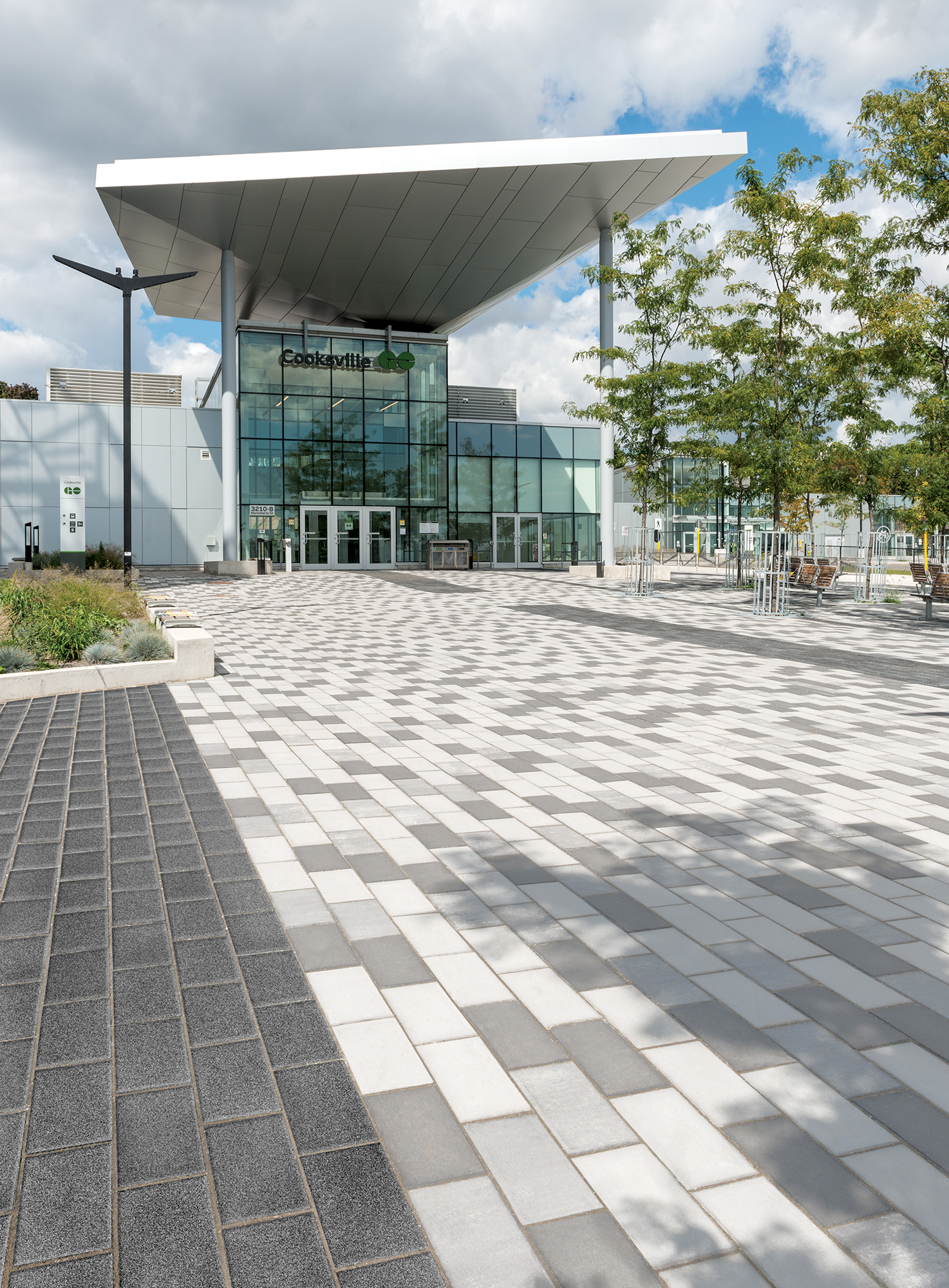 Tri-colored Promenade Plank pavers lead toward the Cooksville Go station, mimicking the building's modern architecture.