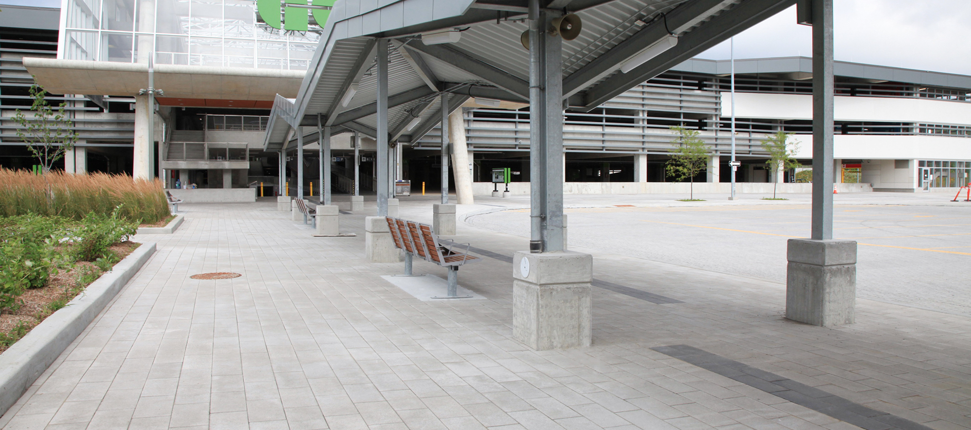 The entrance to Bloomington Go has shelter, benches and landscaping on Grenada white Umbriano pavers with accents in Series Black Granite.